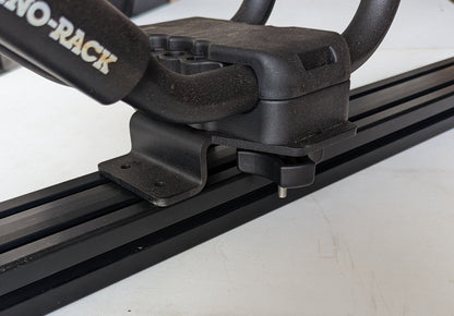 TRUKD Kayak/Gear Mount bracket seated in the T-slot crossbar channel with J-hook saddle hardware