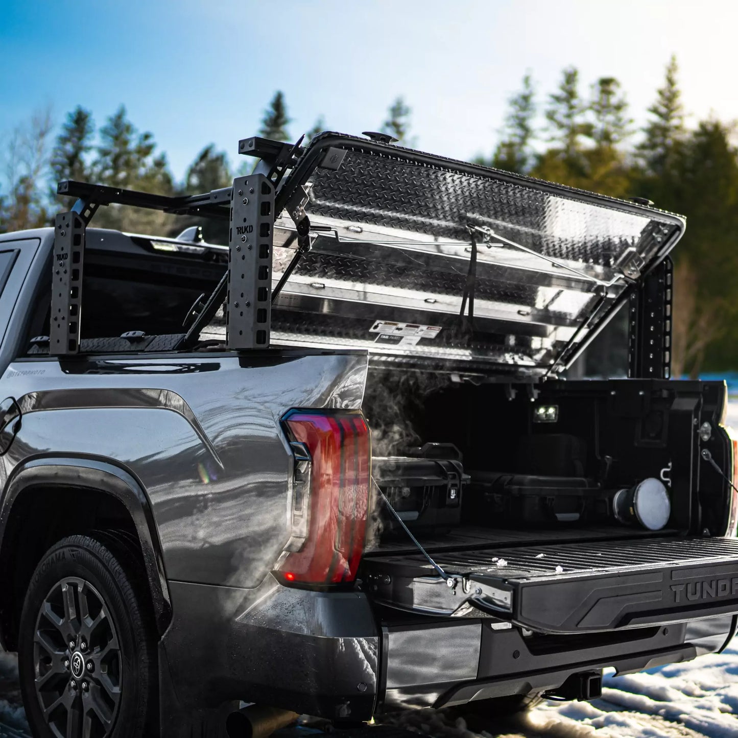 TRUKD T Series Double Decker Bed Rack with 24.5 inch uprights mounted over an open retractable tonneau cover on a Toyota Tundra